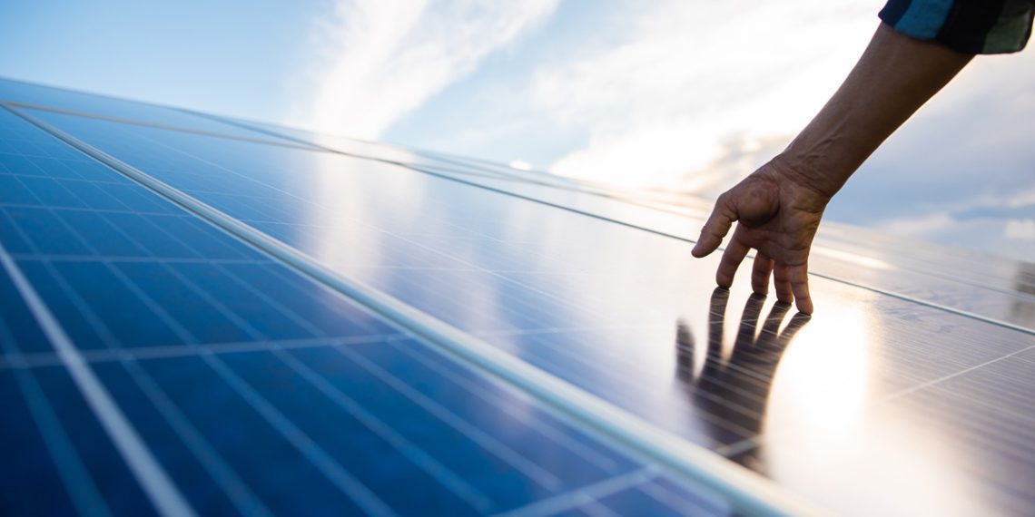 Hands on solar panel that generates energy