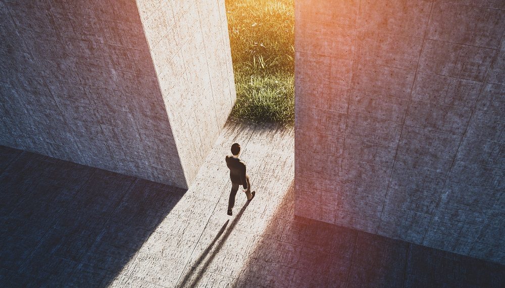 Businessman walking to open gate to a new better green world