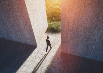 Businessman walking to open gate to a new better green world