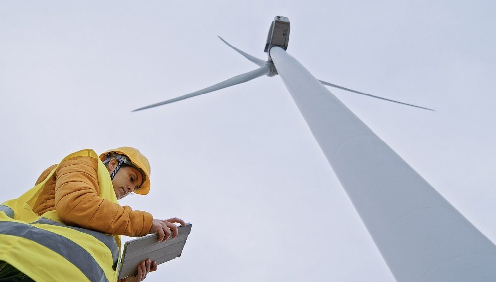 Female wind energy engineer working in wind farm. Renewable Energy Systems. Carbon neutrality and sustainable energy.