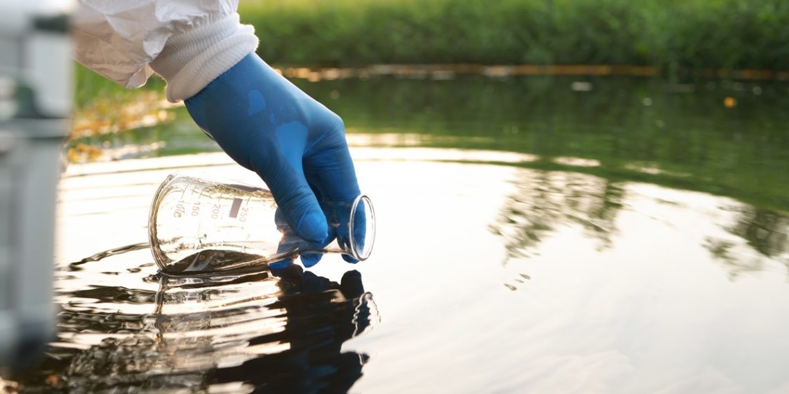 Environment engineer Collect samples of wastewater from industrial canals in test tube, Close up hand with glove Collect samples of wastewater from industrial canals in test tube. mobile water laboratory check