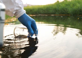 Environment engineer Collect samples of wastewater from industrial canals in test tube, Close up hand with glove Collect samples of wastewater from industrial canals in test tube. mobile water laboratory check