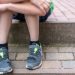 Little boy with broken shoes as a symbol of child poverty
