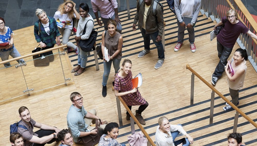 Portrait of university students standing together on staircase