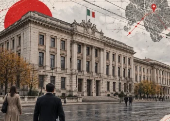 Palazzo ministeriale a Roma sotto un cielo grigio, cavi elettrici e persone di spalle sul marciapiede